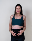 Front view of happy pregnant mother wearing maternity nursing bra in dark green