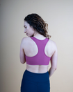 back view of a mum wearing a pink breastfeeding sports bra with racerback