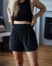 Active mother wearing black mid waisted postpartum shorts ready for a run 