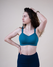 Front view of mother wearing supportive breastfeeding bra in the colour teal