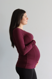 Side on view of pregnant women wearing a bamboo long sleeve top