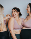 Three happy mothers wearing pink nursing sleep bras