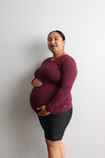 Gorgeous pregnant mother wearing a burgandy long sleeve breastfeeding top