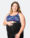 front view of a happy and active pregnant woman showing her bump and nursing sports bra