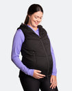 Happy mother wearing a black women's puffer vest over her maternity clothing