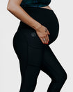 Side view of pregnant mother wearing black maternity leggings