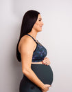 pregnant woman shows supportive maternity bra for larger bust and leggings for pregnancy
